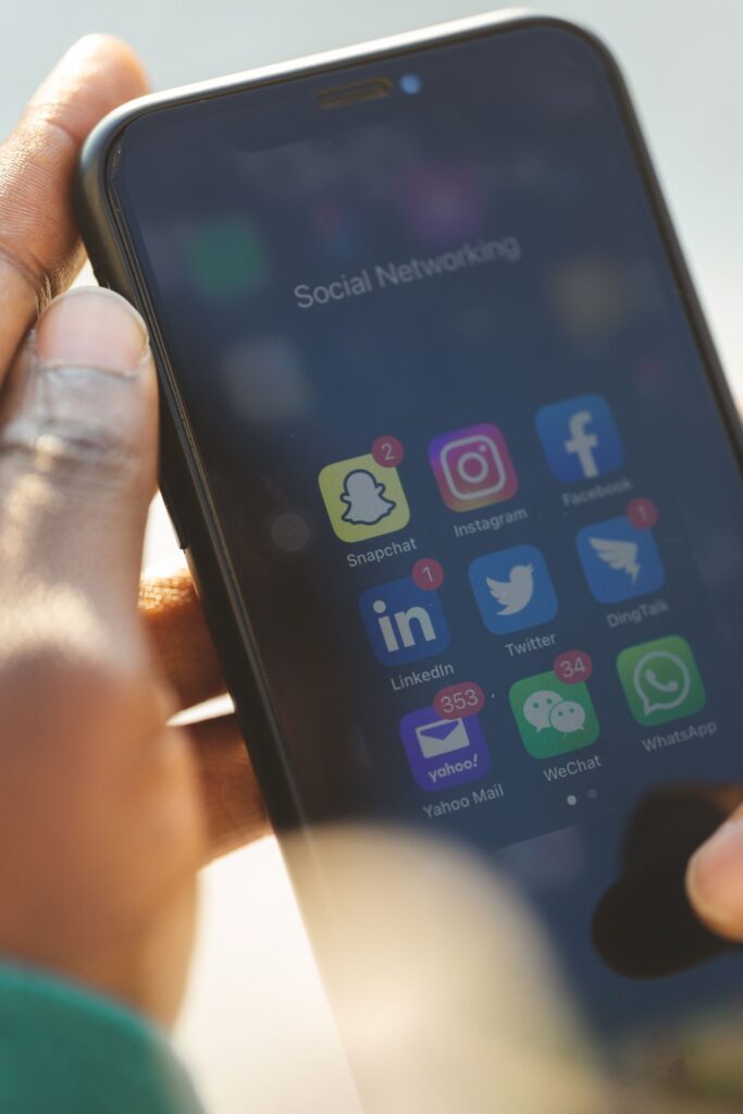 Hand holding smartphone with social media apps open