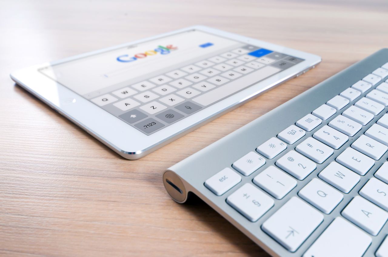 Keyboard and Google search page representing website FAQs